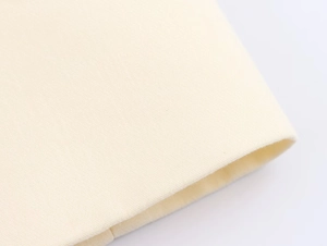 Macro shot of cream single-breasted long blazer showing fine fabric texture and hem detail
