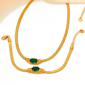 Gold stainless steel snake chain set with green oval stones on elegant silk fabric