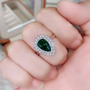 Dettaglio dell'anello a goccia con smeraldo e doppio alone di zirconi sulla mano