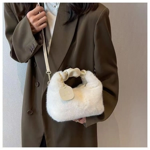 Close-up of white plush handbag with gold chain detail and soft faux fur texture