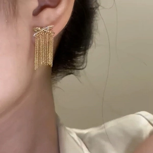 Elegante 14k vergoldete Schleifenohrringe mit Zirkonia und langen Ketten-Quasten an einem Model