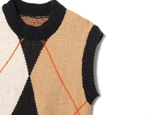 Detail of V-neck argyle knit vest with classic black and brown diamond pattern