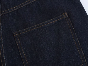 Gros plan détaillé d'une poche arrière en denim bleu foncé avec surpiqûres orange