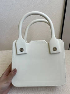 Close-up of the white square EVA handbag with unique circular metal handle connectors