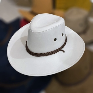 Détail du chapeau de cowboy en cuir blanc avec cordon tressé brun et évents métalliques