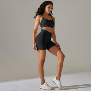 Détail d'un ensemble de yoga noir sans couture avec soutien-gorge croisé et short côtelé