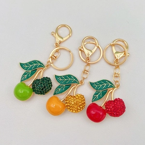 Detailed macro of cherry keychains featuring enamel coating and sparkling rhinestone accents