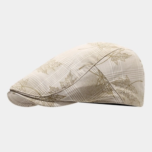 Detail of plaid newsboy cap featuring autumn leaf patterns on high-quality fabric