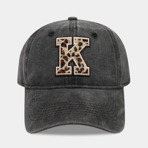 Detail of dark grey vintage baseball cap featuring a leopard print letter K embroidery