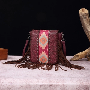 Macro detail of wine red embossed leather bag with ethnic weaving and fringe accents