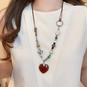 Detailed view of the heart-shaped stone pendant and colorful ethnic beads on the necklace