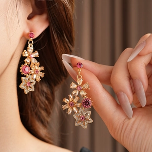 Detail of vintage gold flower earrings with pink and clear crystals on model's ear