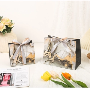 Detailed view of grey gold marble texture gift bags with elegant ribbon and rope handles