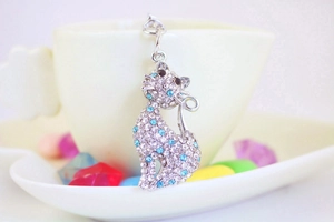 Macro view of silver cat keychain featuring clear and blue rhinestones on a tea cup