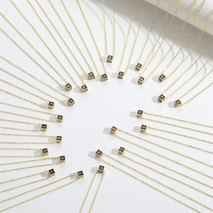 Radial layout of 26 letters square pendant necklaces with gold chain on white background