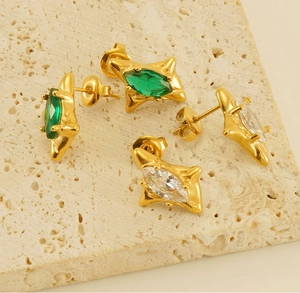 Detail of 18k gold plated starburst earrings with marquise emerald and zircon stones