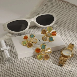 Détails de boucles d'oreilles fleurs en œil de chat coloré avec bords dorés