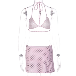 Detailed view of pink polka dot bikini top and matching mini skirt on a mannequin