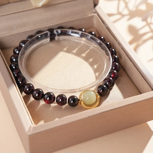 Détail du bracelet en perles de grenat avec jade vert dans un cadre en métal doré