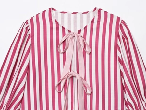 Détail du haut rayé rose à manches longues avec double fermeture à nœud élégant