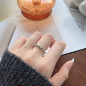 Close-up of S925 sterling silver ring featuring green and white eternity band crystals
