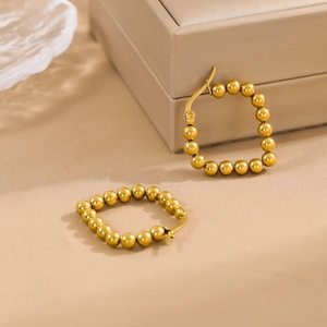 Modern gold beaded square hoop earrings displayed on elegant beige silk fabric