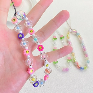 Close-up of a colorful beaded phone strap with acrylic smiley faces and clear flower charms