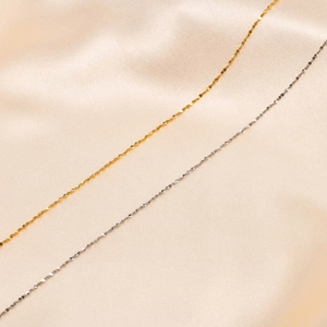 Minimalist titanium steel shimmer chain necklaces in gold and silver on silk fabric