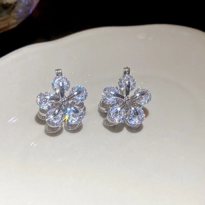 Macro shot of silver flower earrings featuring sparkling zircons with a starburst effect