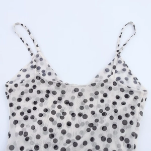 Detailed view of the black polka dots on white mesh fabric and thin shoulder strap
