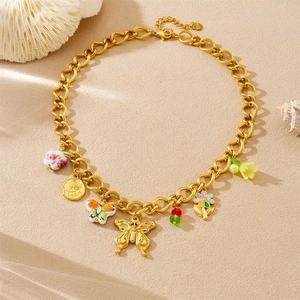 Detail of gold chain necklace with colorful enamel flower, butterfly, and cherry charms