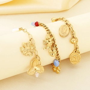 Detail of gold layered bracelets with flower, angel, and religious coin charms