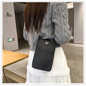 Detail der schwarzen Handy-Tasche mit Krokodil-Textur und gewebtem Jacquard-Schultergurt