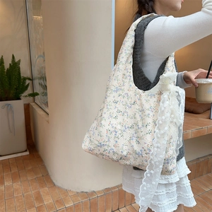 Detail of floral canvas tote bag featuring white lace bow accent and delicate flower pattern