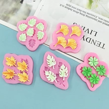 Detail of five pink silicone leaf molds showing ginkgo and maple leaf shapes