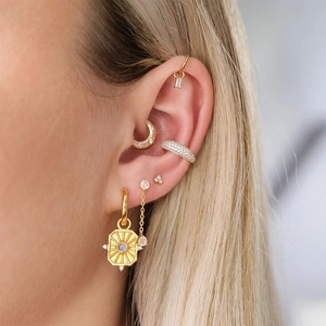 Close-up of S925 silver geometric hoop earrings and ear cuffs with cubic zirconia inlay