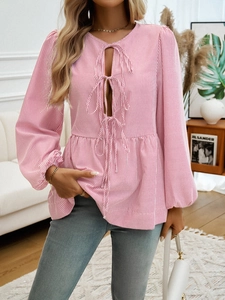 Detail of pink striped blouse featuring long lantern sleeves and front tie-up cutout design