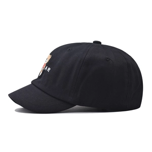 Detail shot of a black short brim baseball cap featuring a rainbow bear embroidery