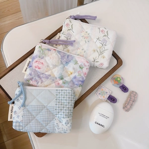 Detailed macro view of quilted floral pouches in lavender and blue checkered patterns