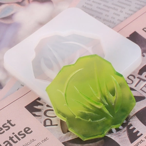 Close-up of semi-transparent silicone mold and finished green resin pendant with textures