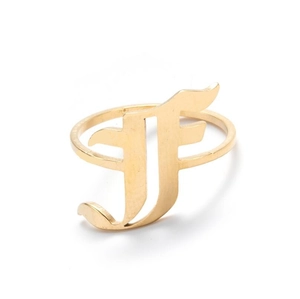 Macro detail of gothic letter F signet ring in gold finish with vintage metal texture