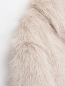 Gros plan sur la texture en fausse fourrure beige et la matière pelucheuse de la veste