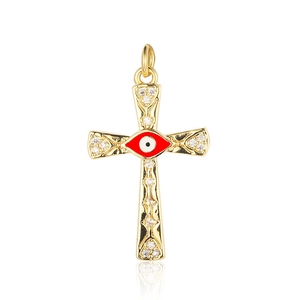 Detailed shot of a gold cross pendant with a red evil eye and clear zircon stones