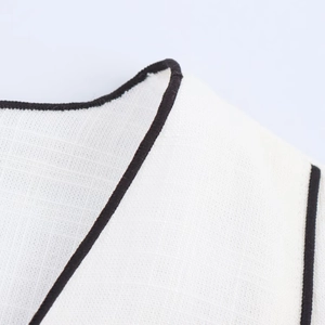 Macro shot of high-quality white linen fabric texture with black contrast piping detail