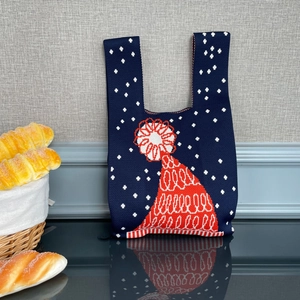Détail du sac tricoté de Noël avec motif de chapeau rouge et textures de flocons