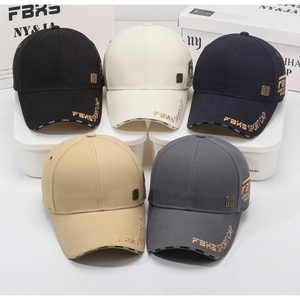 Detail view of five baseball caps with embroidered letters and metal badges on canvas