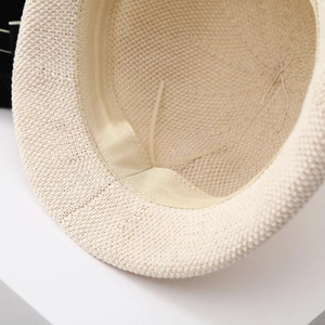 Detailed macro view of the inner sweatband and adjustable drawstring on beige straw hat