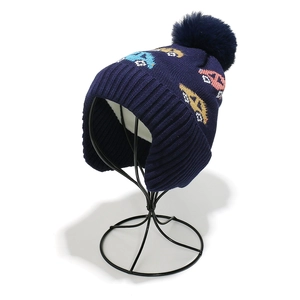 Detail of warm navy blue kids winter hat with car pattern and thick inner lining