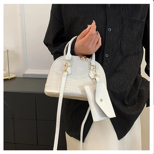 Detail of white crocodile pattern shell bag with mini coin purse and gold hardware