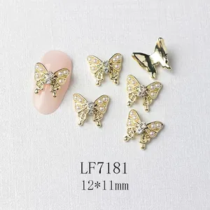 Detailed view of 12x11mm gold butterfly nail charm with white pearls and center rhinestone
